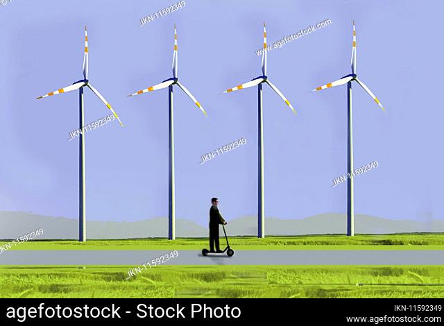 Man riding electric scooter past wind turbines