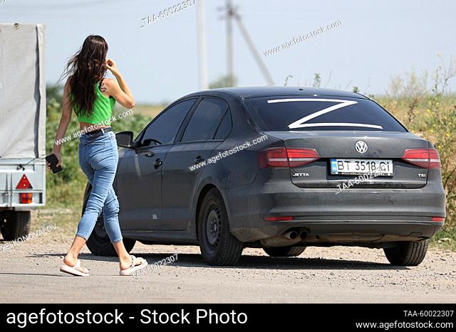 RUSSIA, KHERSON REGION - JUNE 23, 2023: A woman walks along as vehicles queue to pass the Armyansk checkpoint between the Kherson Region and Crimea