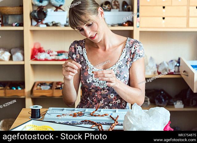 Woman making a necklace from gemstones as her hobby project
