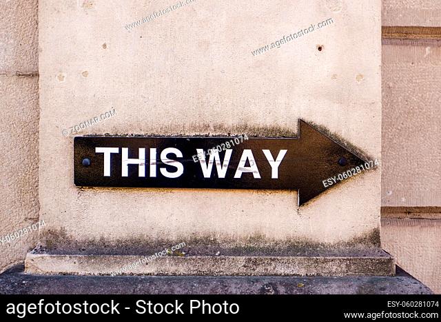This way sign in black on a wall in Kendal