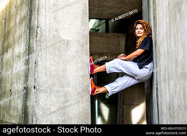 Smiling woman balancing while climbing wall