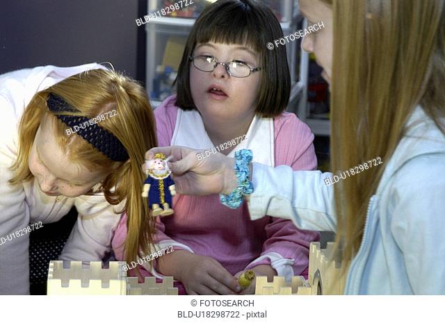 Children, including a child with Down Syndrome, playing with a castle