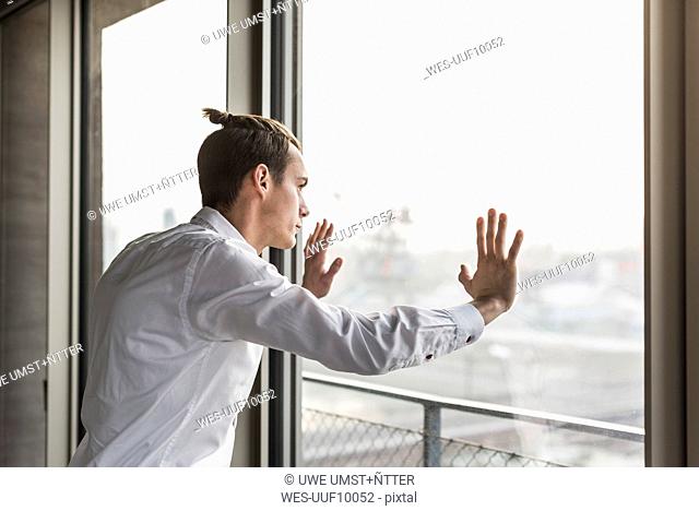Young businessman looking out of window