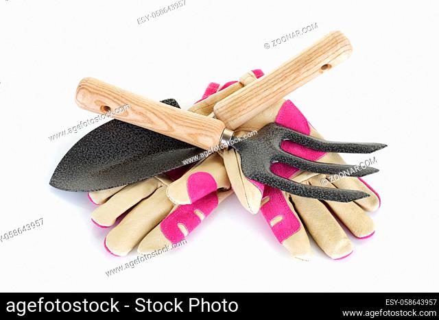 A garden fork trowel and gloves on white