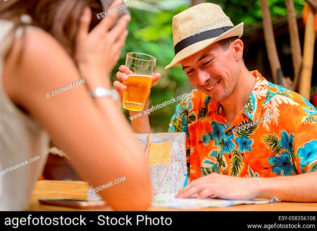 Portrait of young tourist man and young Asian tourist woman together at restaurant in the city outdoors