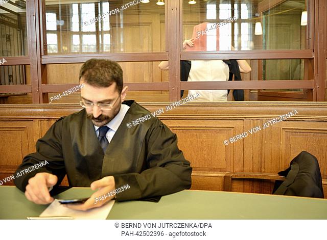 Defendant Mehmet O. covers his face with a folder in the courtroom in Berlin-Moabit,  Germany, 12 September 2013. Mehmet O is being charged with shooting his...
