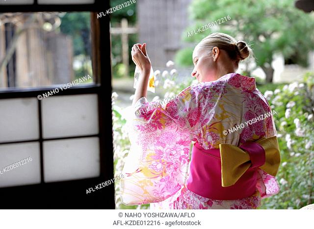 Caucasian woman wearing yukata in traditional Japanese house