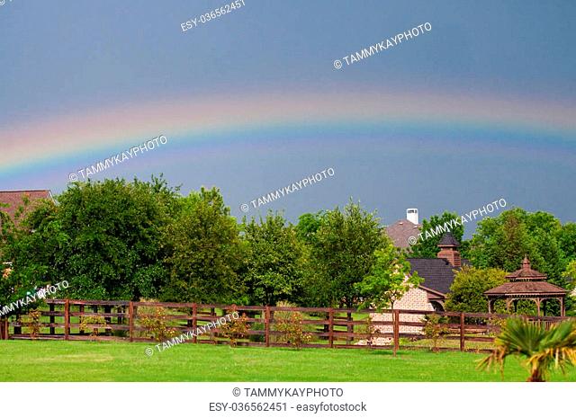 Beautiful rainbow in the sky in the backyard of a residential neighborhood