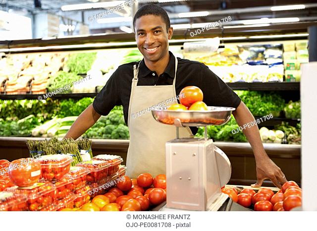 Worker weighing fruit in supermarket