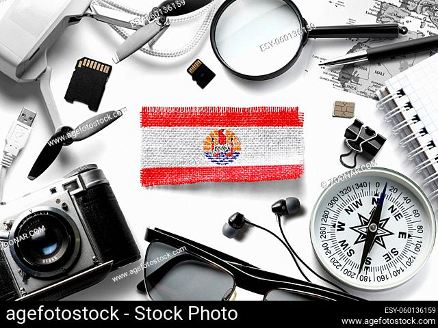Flag of French Polynesia and travel accessories on a white background. The view from the top