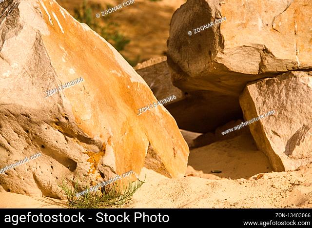 Sedimentary sand and cracked rocks on sandy rocky beach with huge layers of piled dust dirt stone and cliff, texture and grit