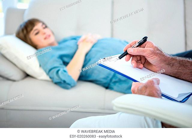Midsection of gynecologist writing prescription on clipboard