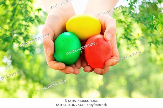 close up of girl with bowl of colored easter eggs