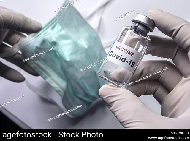 Scientist holds a coronavirus vaccine, conceptual image