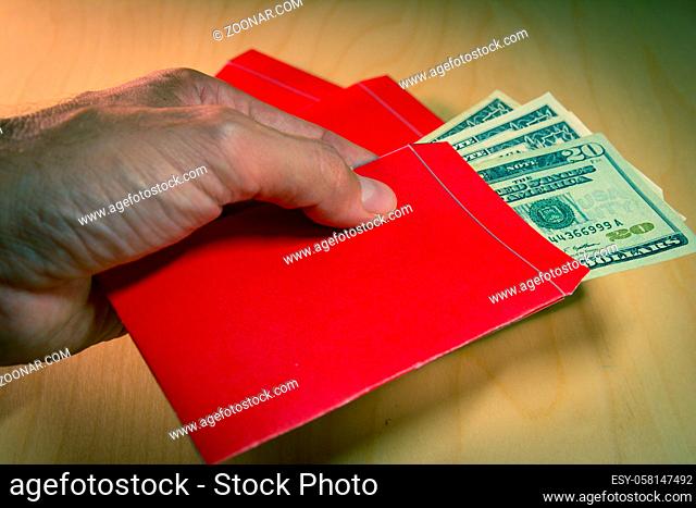 The red envelope or hong bao is used for giving money during the Spring Festival, or Chinese New Year in China and Taiwan. Envelope and dollar bills