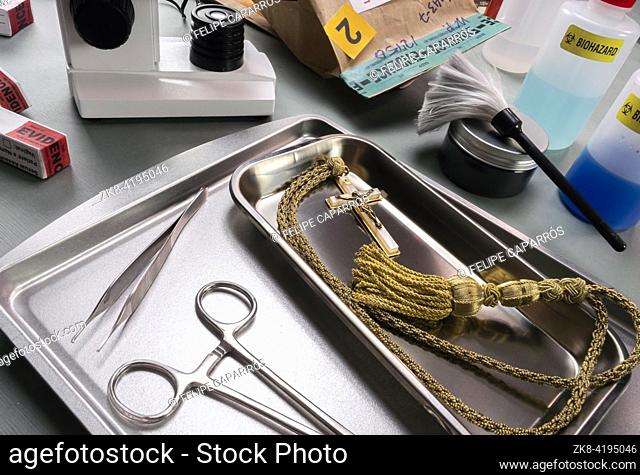 Crucifix with gold cord from a religious homicide, DNA research in a crime lab, conceptual image