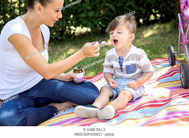 Mother feeding her little son on a blanket