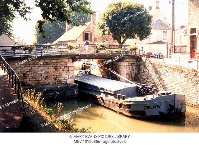The Canal de Loing at Montargis : the barge 'Edelweiss' lowers its mast to pass beneath a low bridge