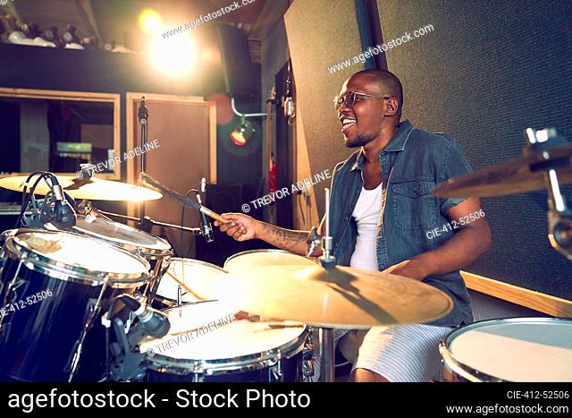 Male musician playing drums in recording studio
