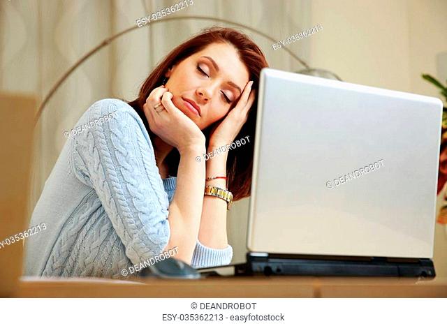 Tired woman with closing eyes sitting on her workout at home