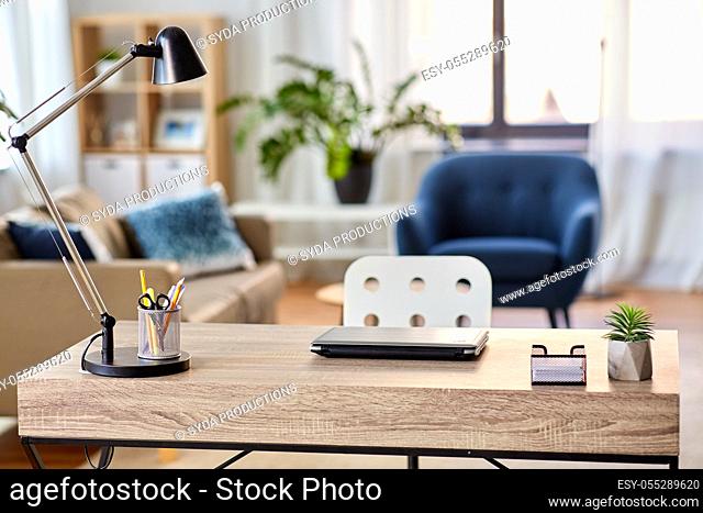 laptop and lamp on table at home office