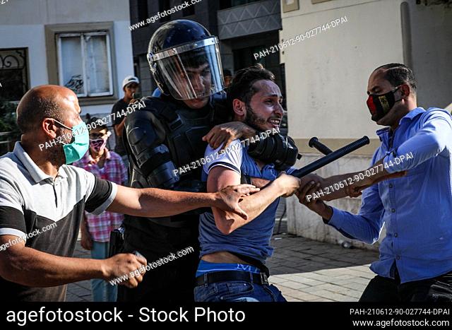 12 June 2021, Tunisia, Tunis: Tunisian security forces detain a protester during a protest against police violence, following the death of a young man who was...