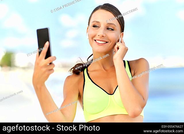 woman with earphones and smartphone doing sports