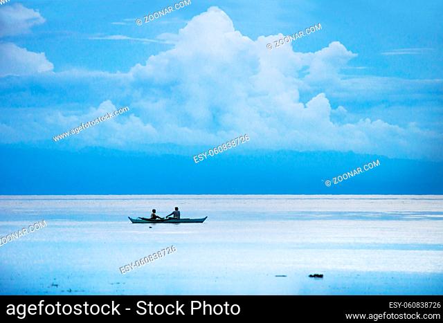 Fisherboat in the endless blue white ocean and huge cloud at Siquijor with mountain, Philippines, Asia