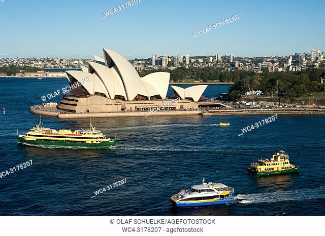 Sydney, New South Wales, Australia - An elevated view of the Sydney Opera House on Bennelong Point with ferry boats in the bay