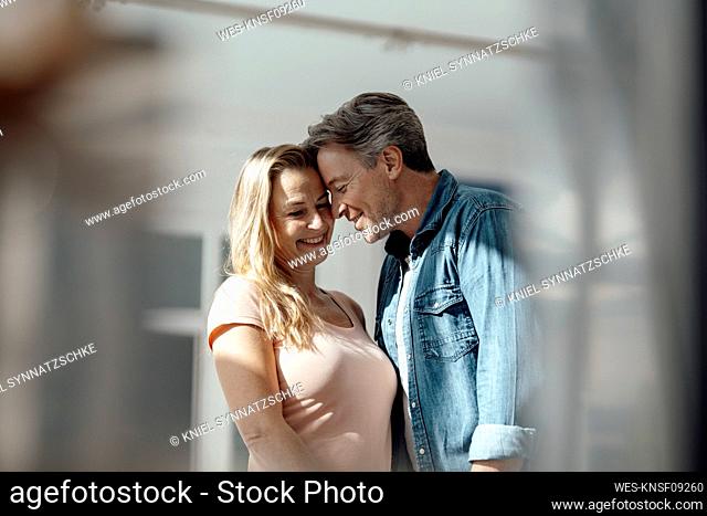 Smiling couple embracing each other at home