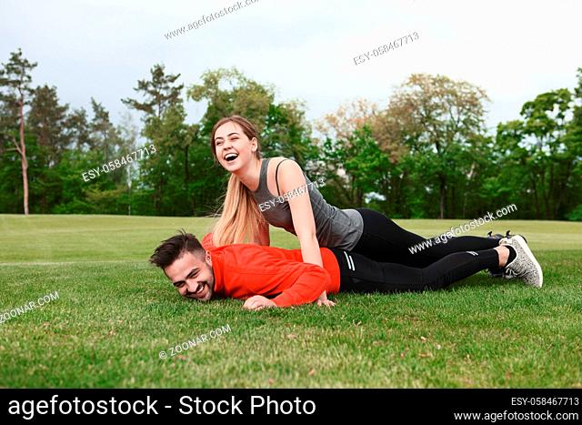 Picture of sport man and woman having fun in park while training and exercising with nature on fresh air