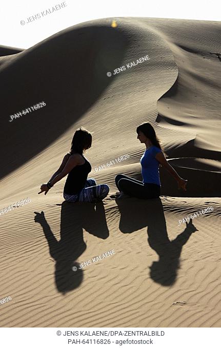 Participants of a Nosada Yoga tour doing yoga exercises in the Erg Chebbi desert near Merzouga, South of Morocco, 09 November 2015