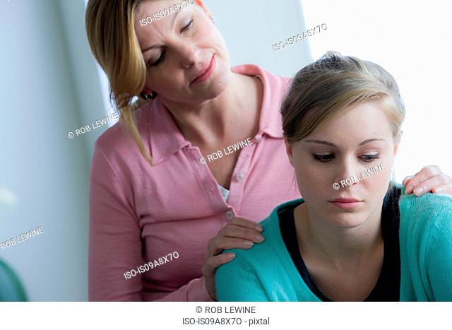 Mother comforting teenage daughter