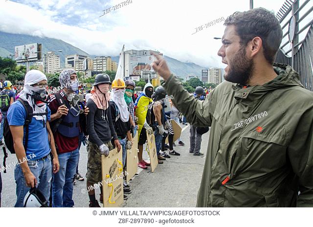 Deputy Juan Requesens speaks to the press in protest at the military base. Opposition protesters assembled on the Francisco Fajardo motorway