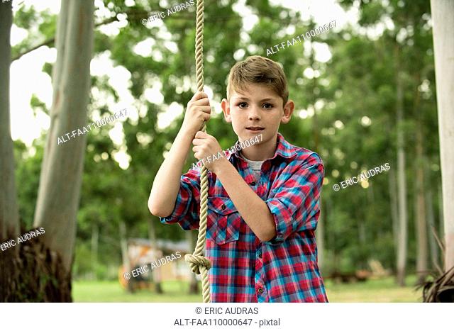 Boy on rope swing, portrait