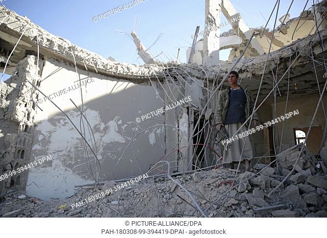 dpatop - A Yemeni man inspects a destroyed house that was allegedly targeted by Saudi-led air strikes in Sanaa, Yemen, 08 March 2018