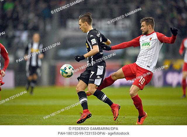 Borussia Moenchengladbach and FC Augsburg face off at a Bundesliga match in Moenchengladbach, Germany, 20 January 2018. Gladbach's Patrick Herrmann (l) and...