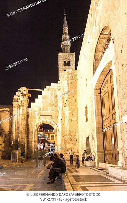 Men sitting at night at the rear door of the Umayyad Mosque in Damascus, Syria