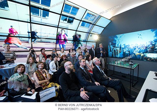 Michael Mueller (1st Row, 2.f.R), Mayor of Berlin watches a film at the opening of the multimedia installation 'Luneta' at the Friedrichstrasse train station in...