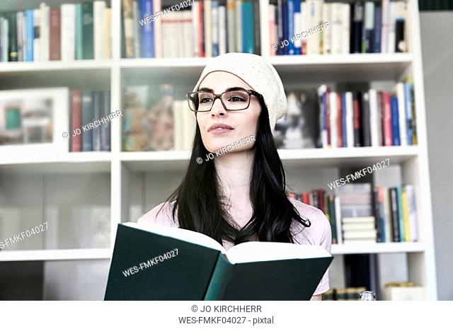 Young woman holding book looking sideways