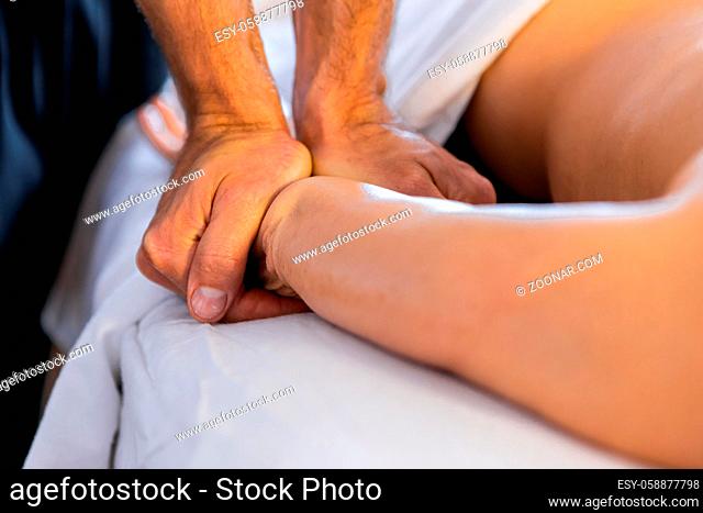 Woman getting a hand massage. The masseur makes a hand massage to a woman in a cosy home environment. Massage and body care