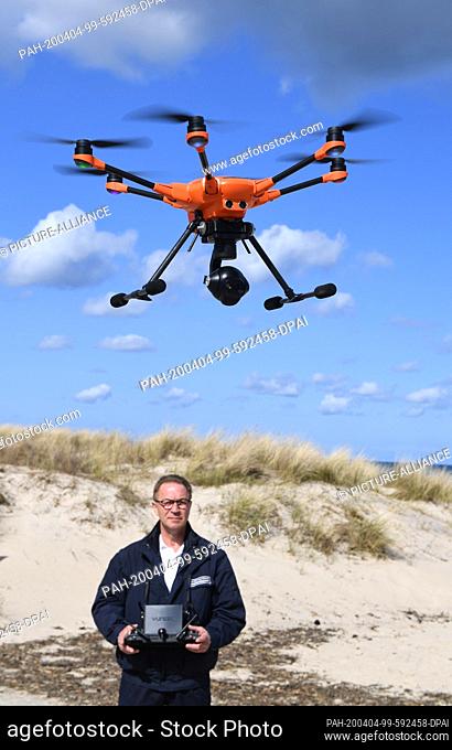 04 April 2020, Mecklenburg-Western Pomerania, Baabe: Dieter Teetz, employee of the Ordnungsamt Mönchgut-Granitz starts a rescuecopter (drone) on the beach of...