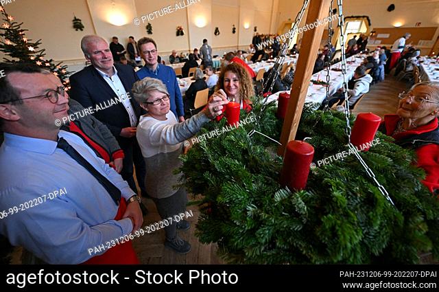 06 December 2023, Thuringia, Erfurt: A candle is lit on the Advent wreath in the Restaurant des Herzens of the Evangelical City Mission. From St