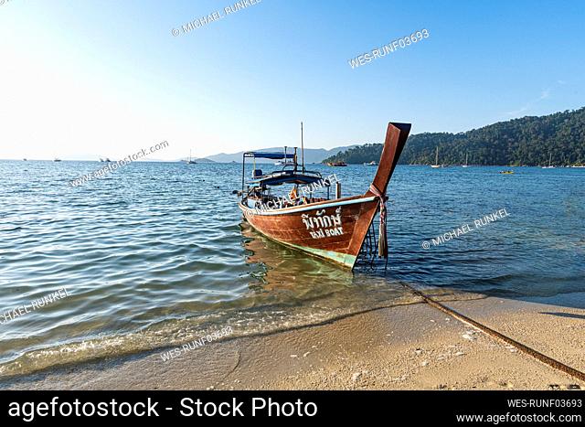 Thailand, Satun Province, Ko Lipe, Fishing boat moored at shore of coastal beach
