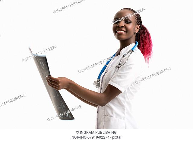 Closeup portrait of intellectual african woman healthcare doctor with white labcoat, looking at brain x-ray radiographic image, ct scan, mri