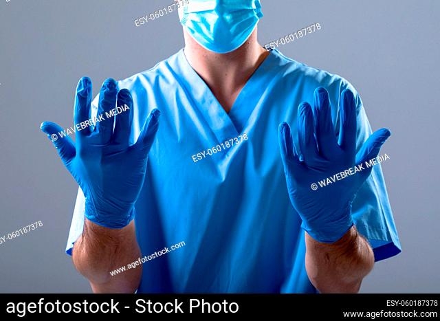 Caucasian male doctor wearing face mask and medical gloves