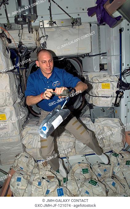 Astronaut Clay Anderson, Expedition 15 flight engineer, uses an air sample pump and 2.5 liter gas sample bag to gather and analyze air samples for the Analyzing...