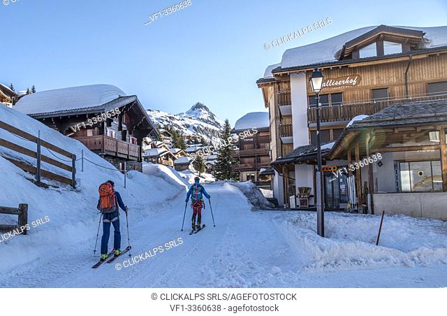 Ski mountaineers in the snowy alpine village of Rideralp, Raron district, canton of Valais, Switzerland