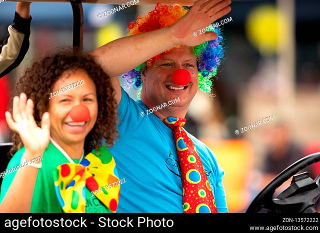 Peru, Indiana, USA - July 21, 2018 Man and a woman wearing clown costumes riding a golf car at the Circus City Festival Parade