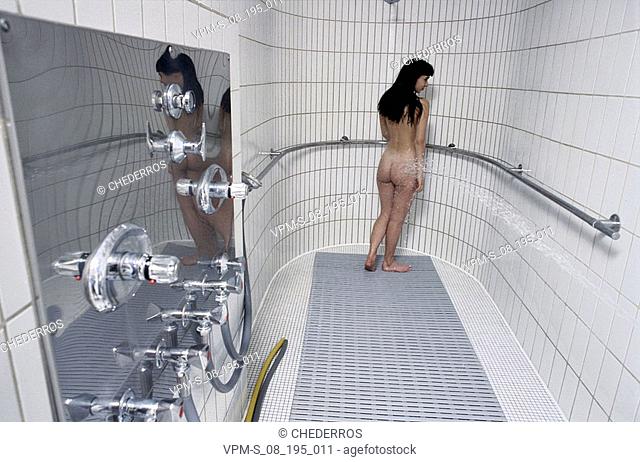 Rear view of a woman standing in the bathroom